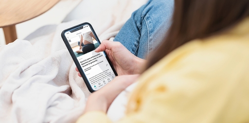 Mujer embarazada navega en el feed personalizado de la app LILLYDOO en su móvil