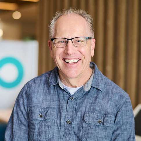 Man with glasses wearing a blue shirt smiling in the donor centre
