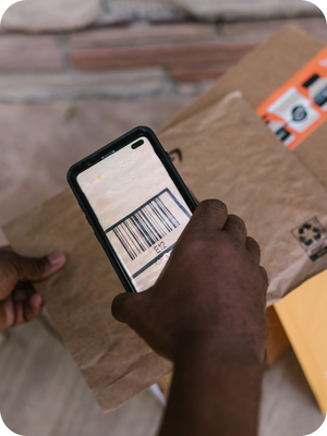 Une main qui tiens un téléphone qui scanne un code barre