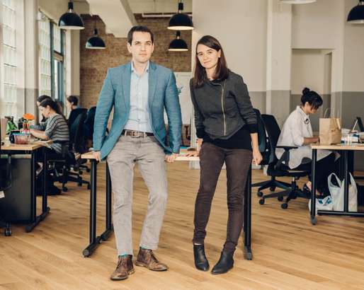 Image of Leah Greenberg and Ezra Levin sitting in an office and looking at the camera.