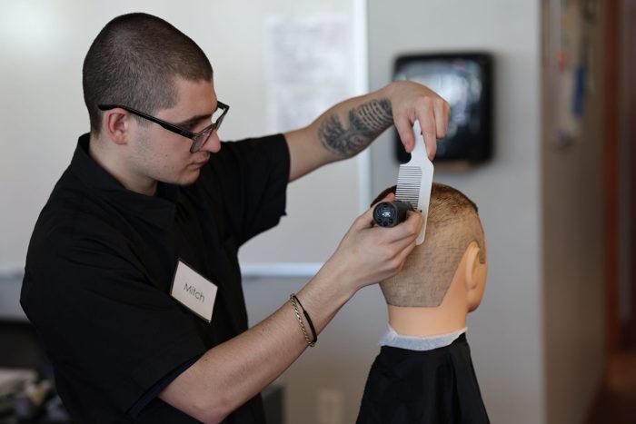 Barbering student practicing a haircut