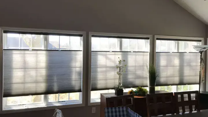 Top-down cellular shades across three tall windows