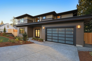 Two white garage doors on a blue house