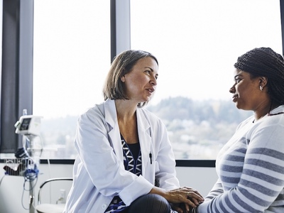 Doctor with stethoscope listening to older woman's lungs