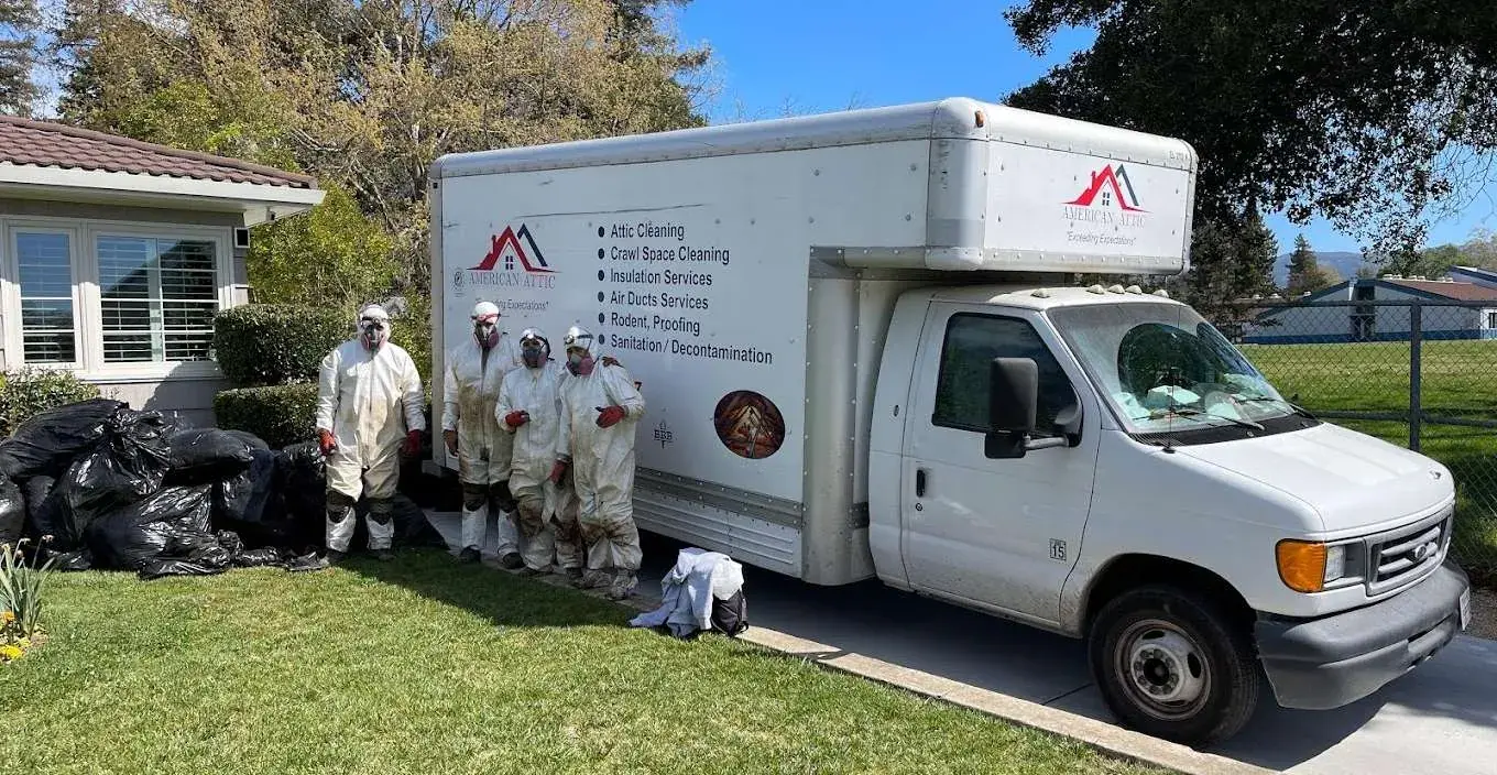 The American Attic crew in protective suits beside the company truck