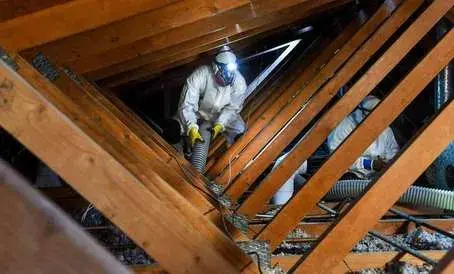 Technician installing blown-in attic insulation