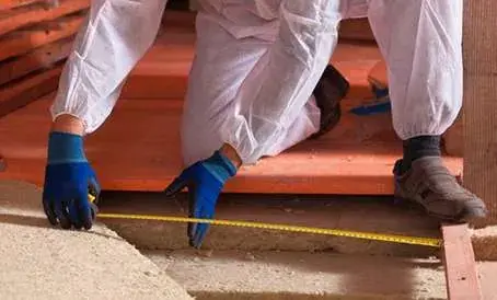 Technician measuring attic insulation