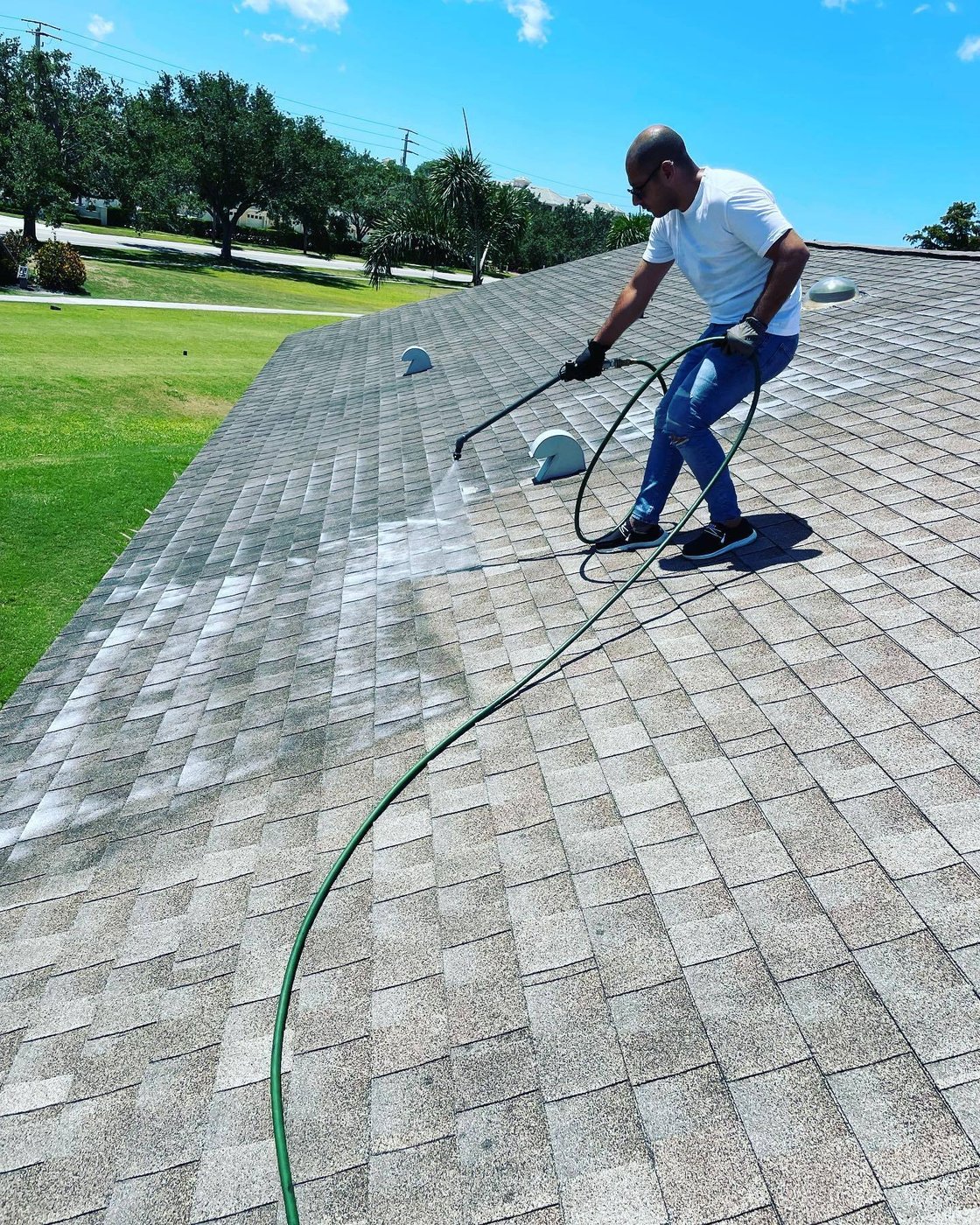 Roofing team applying rejuvenation treatment on a home