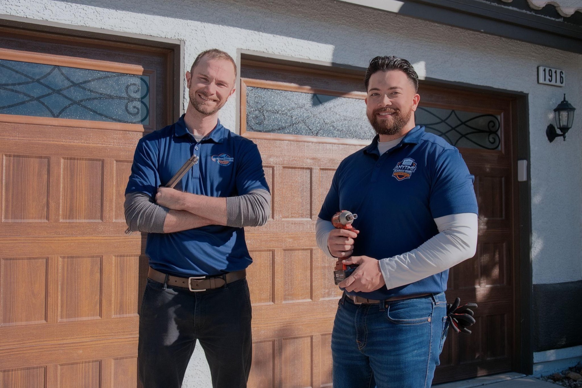 Bingo Garage Doors technicians in front of a repaired garage door