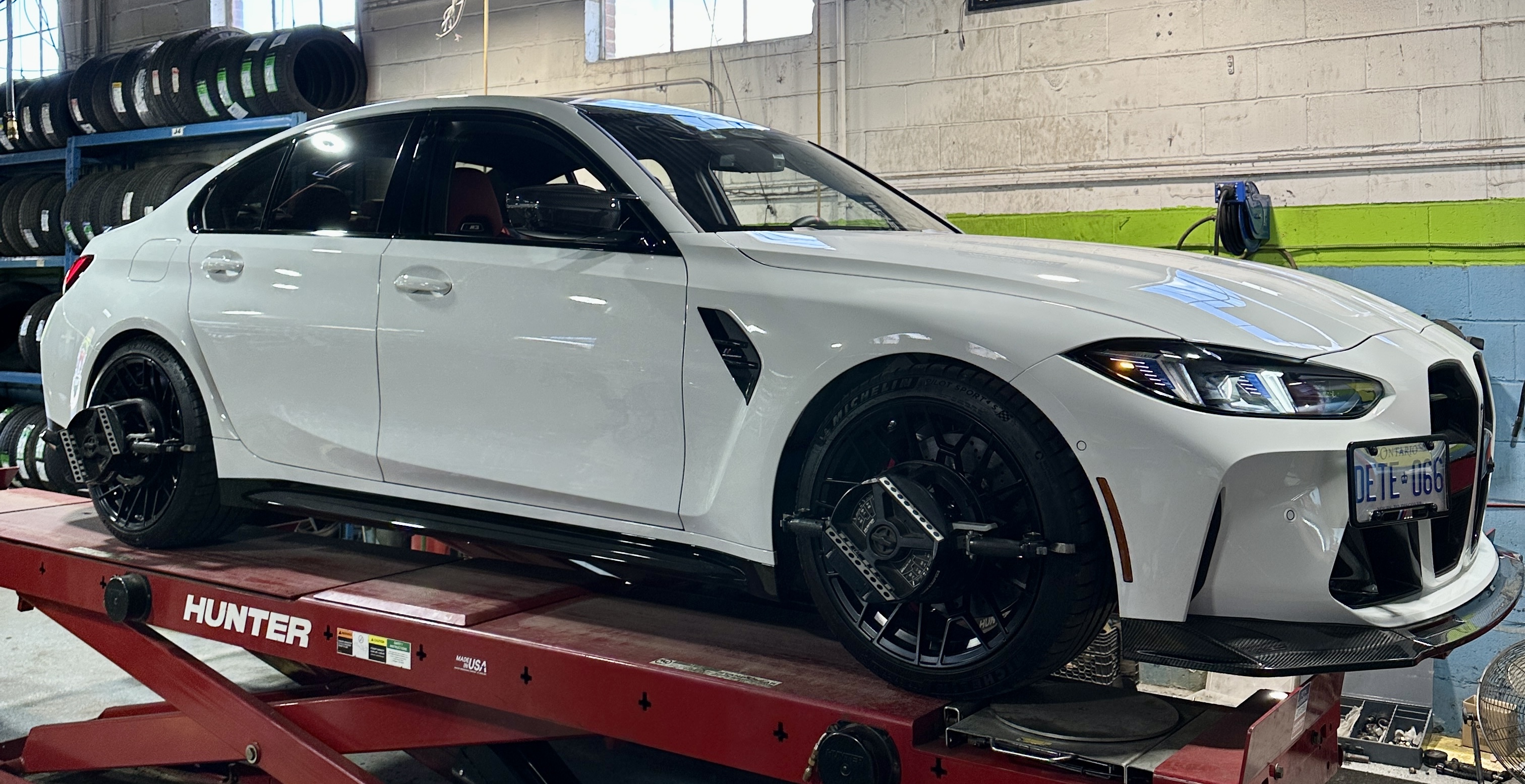 White BMW on the wheel-alignment lift at Green Tires in Scarborough