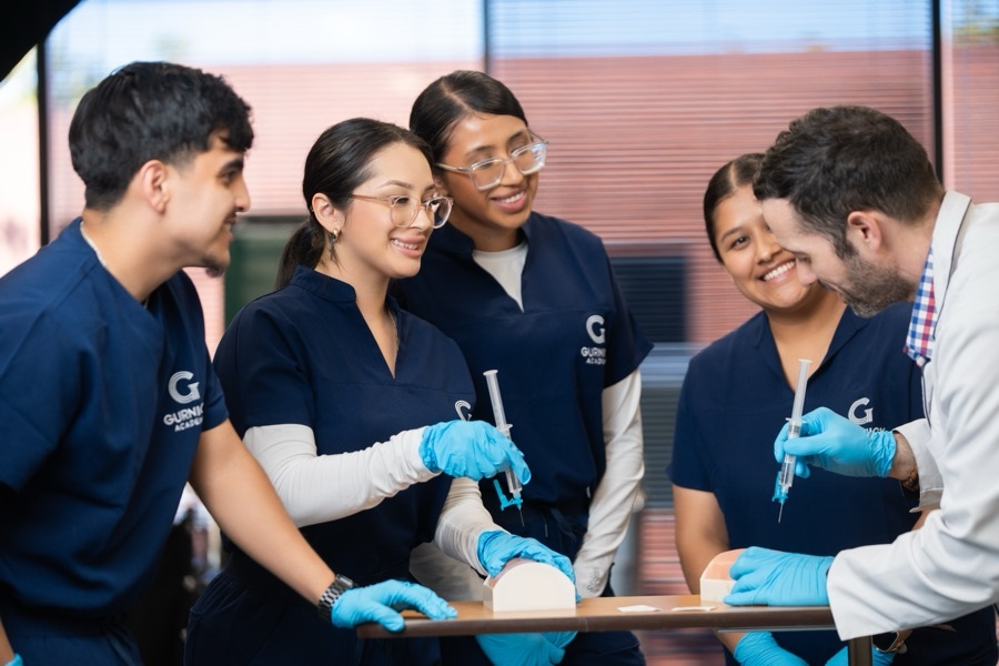 Instructor demonstrating a clinical skill to a small group of vocational nursing students