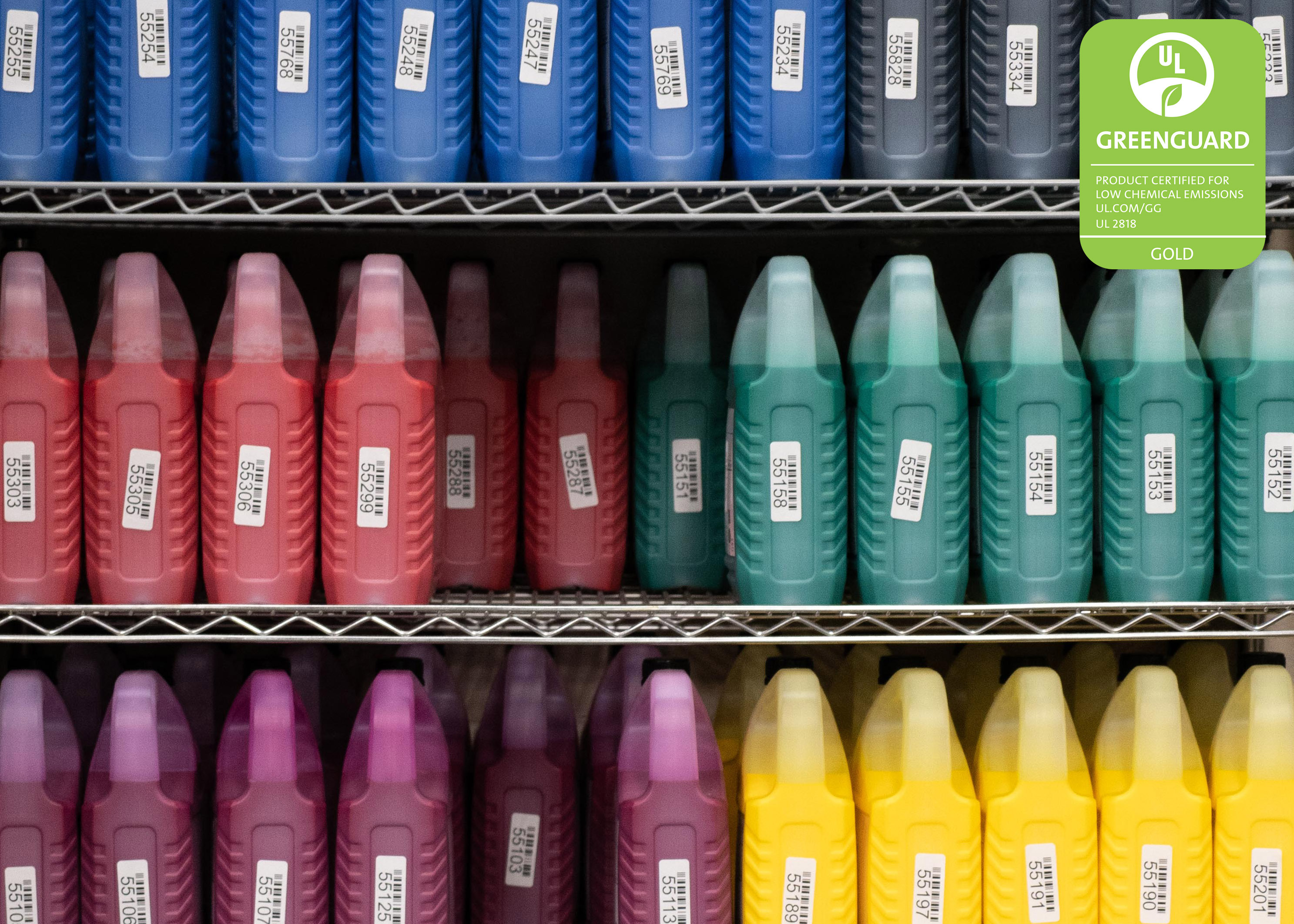 Colorful inks stored on a shelf, with greenguard ink certification logo
