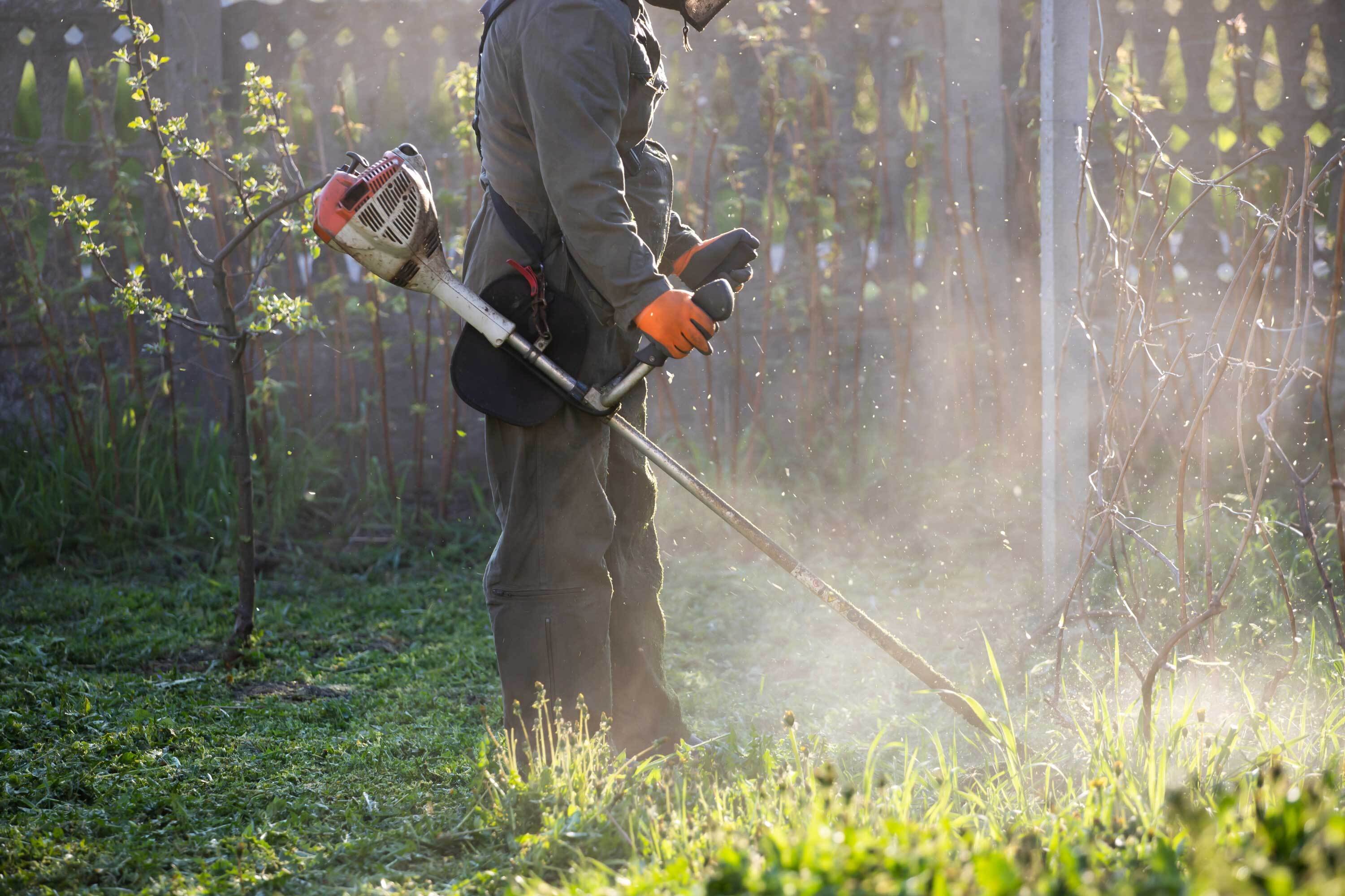 Person cutting grass with weed trimmer.