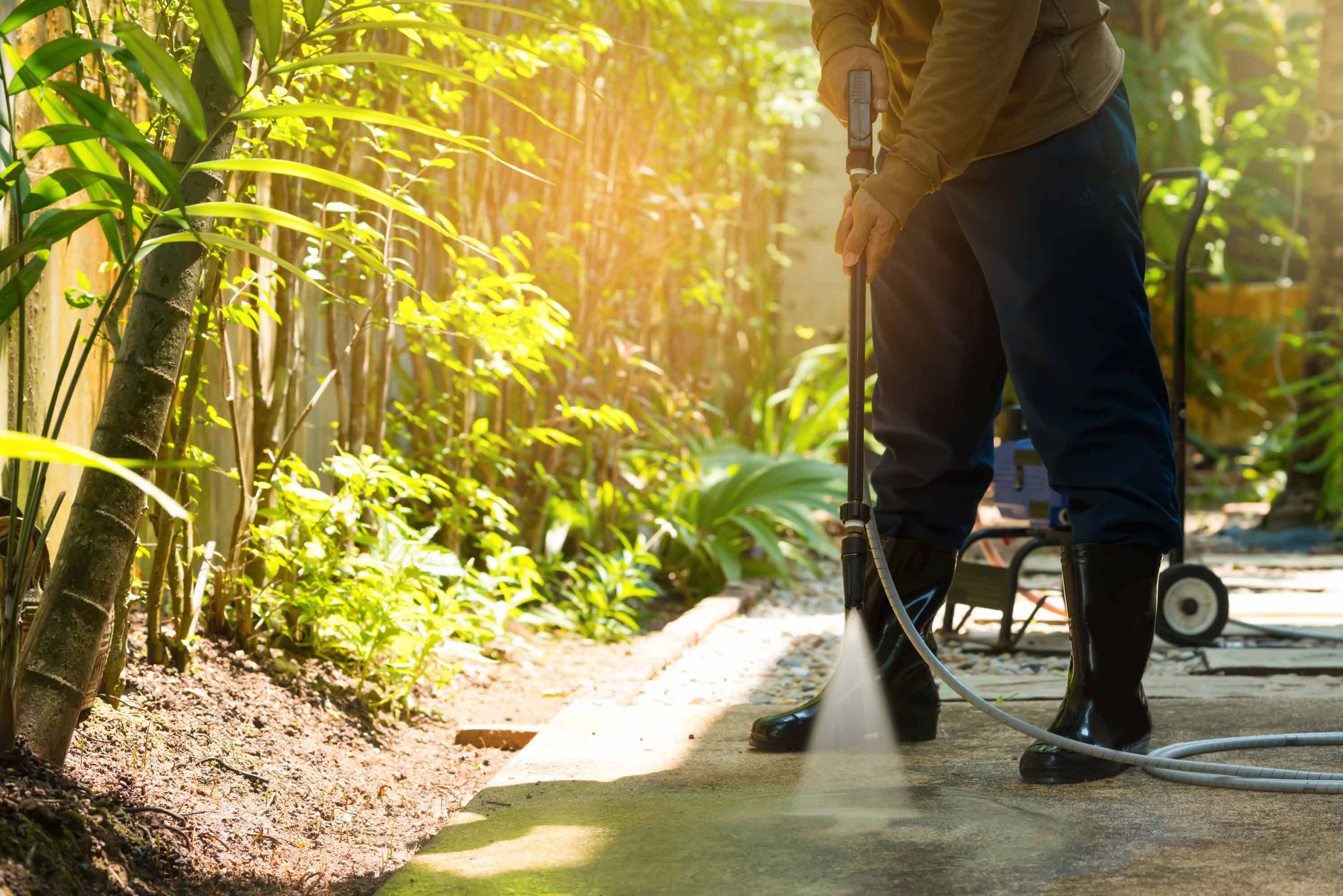 Person pressure washing driveway.