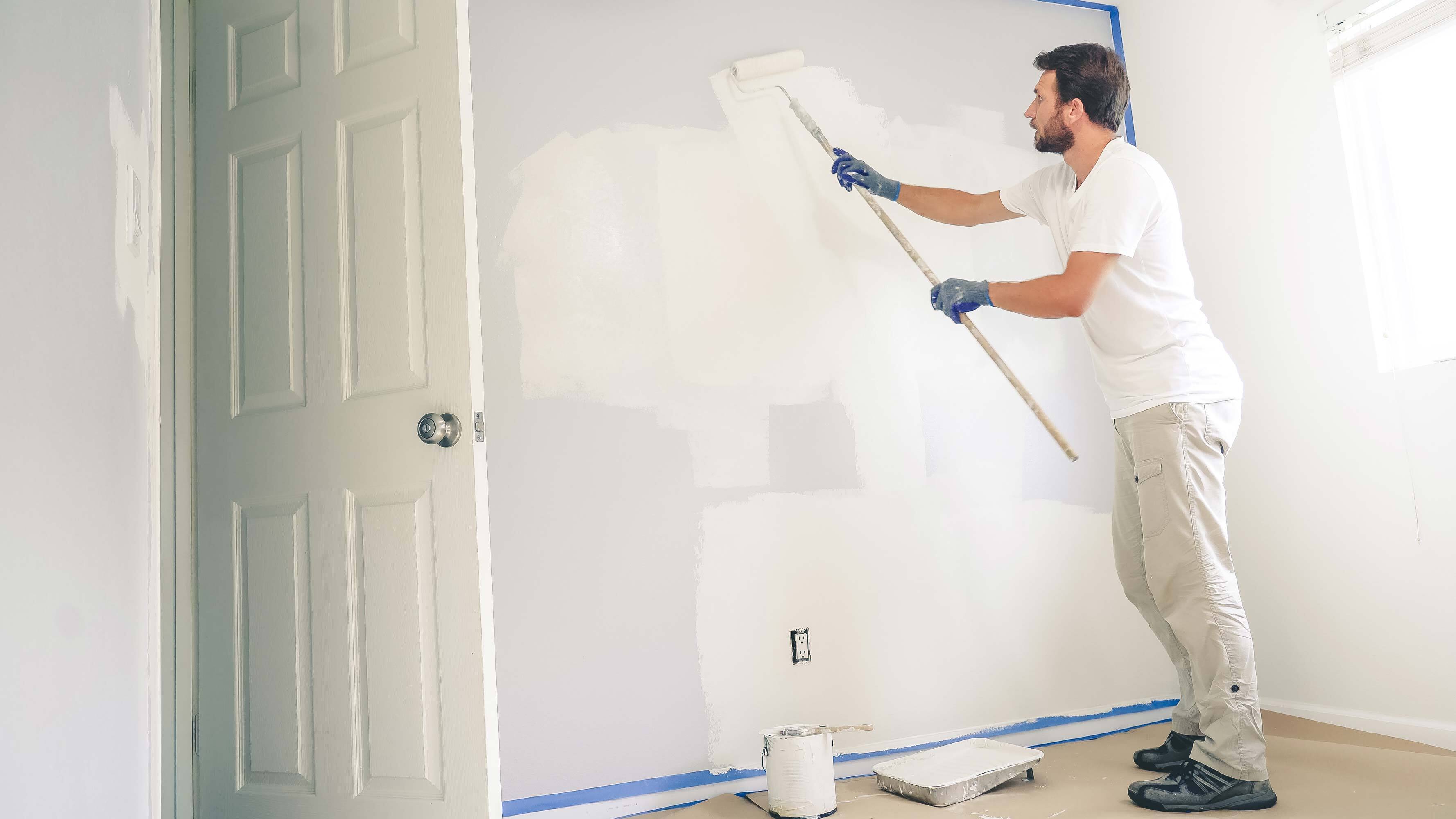 Man painting interior wall.