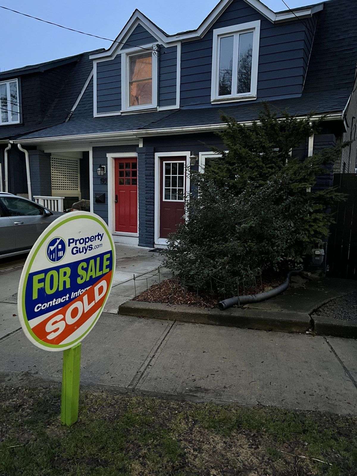 A PropertyGuys.com FOR SALE sign marked SOLD in front of a Toronto house