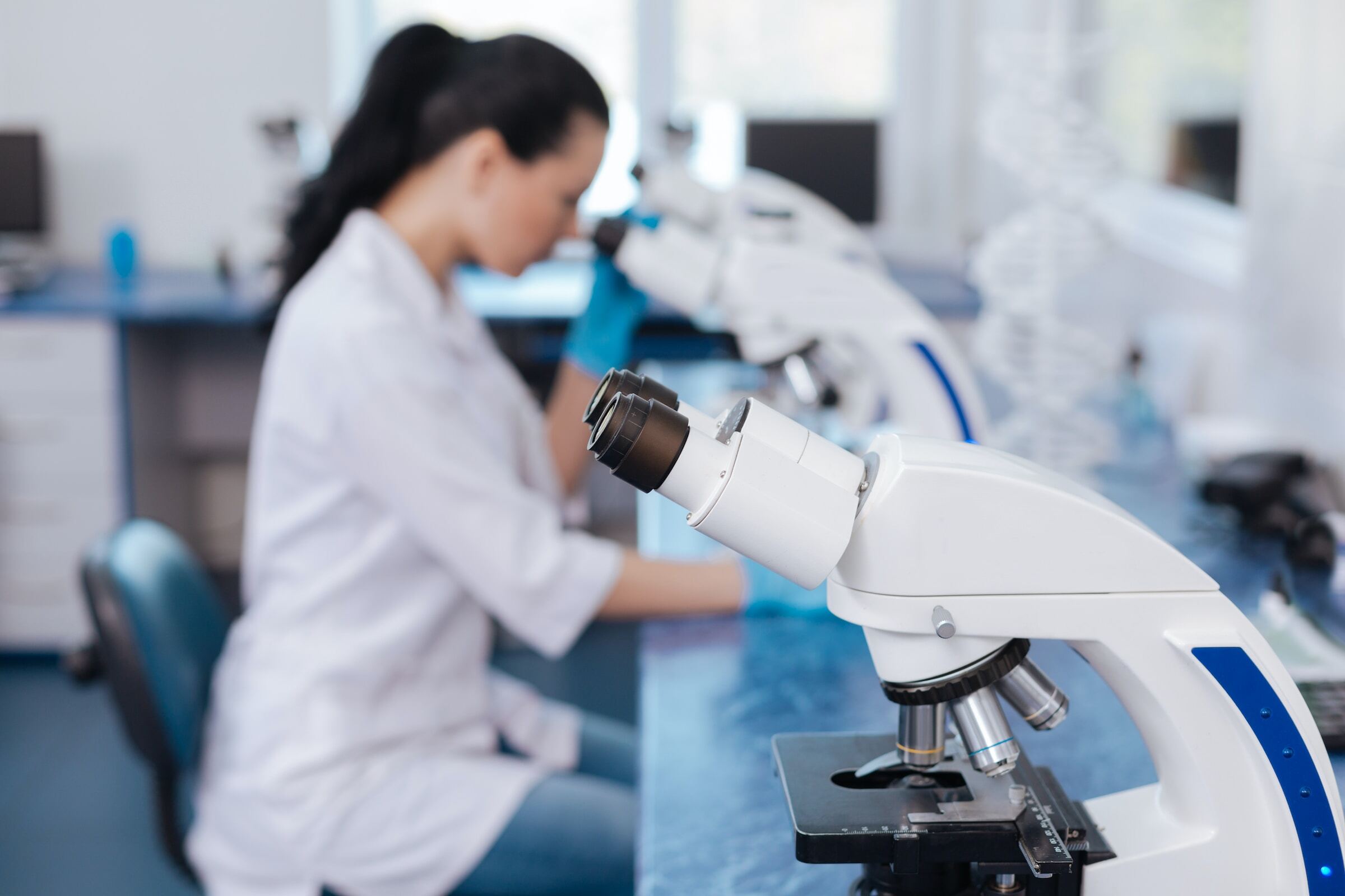 scientist looking through microscope