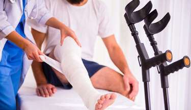 Image of man with leg being treated by medical professional after suffering a catastrophic injury