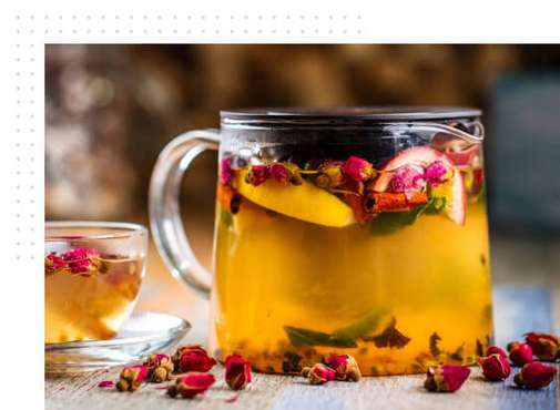 A jar full of cold infusion with herbs and fruit