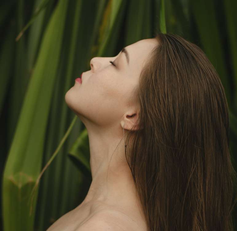 16f4af85 unsplash cyxmpqt0mfe woman on front of green leaves - OrganicR