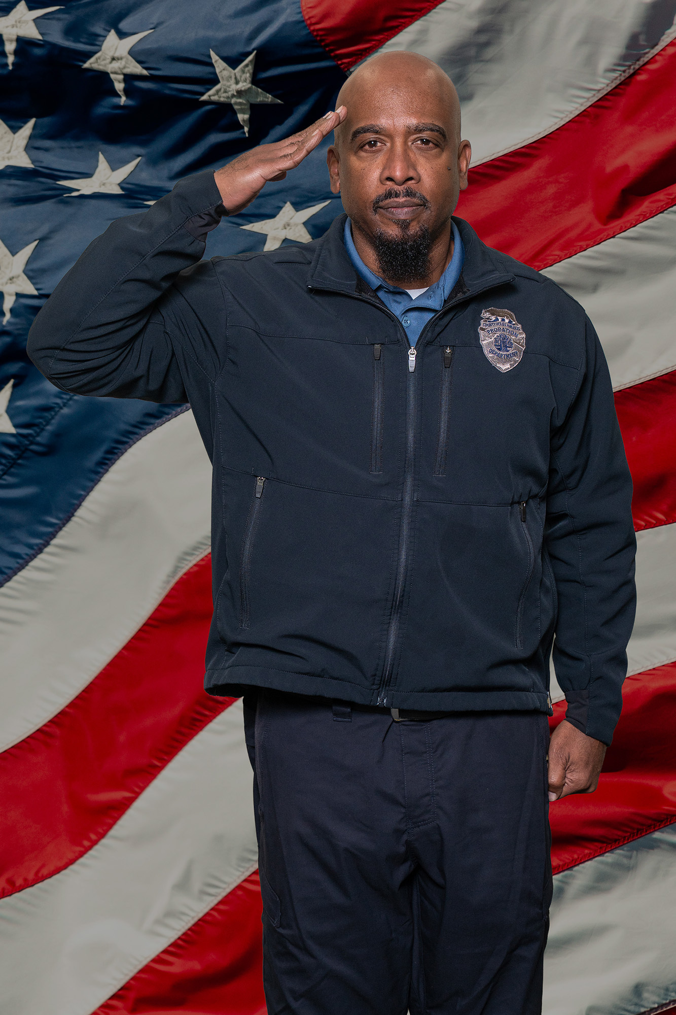 Deputy Probation Officer I standing at attention in front of US Flag