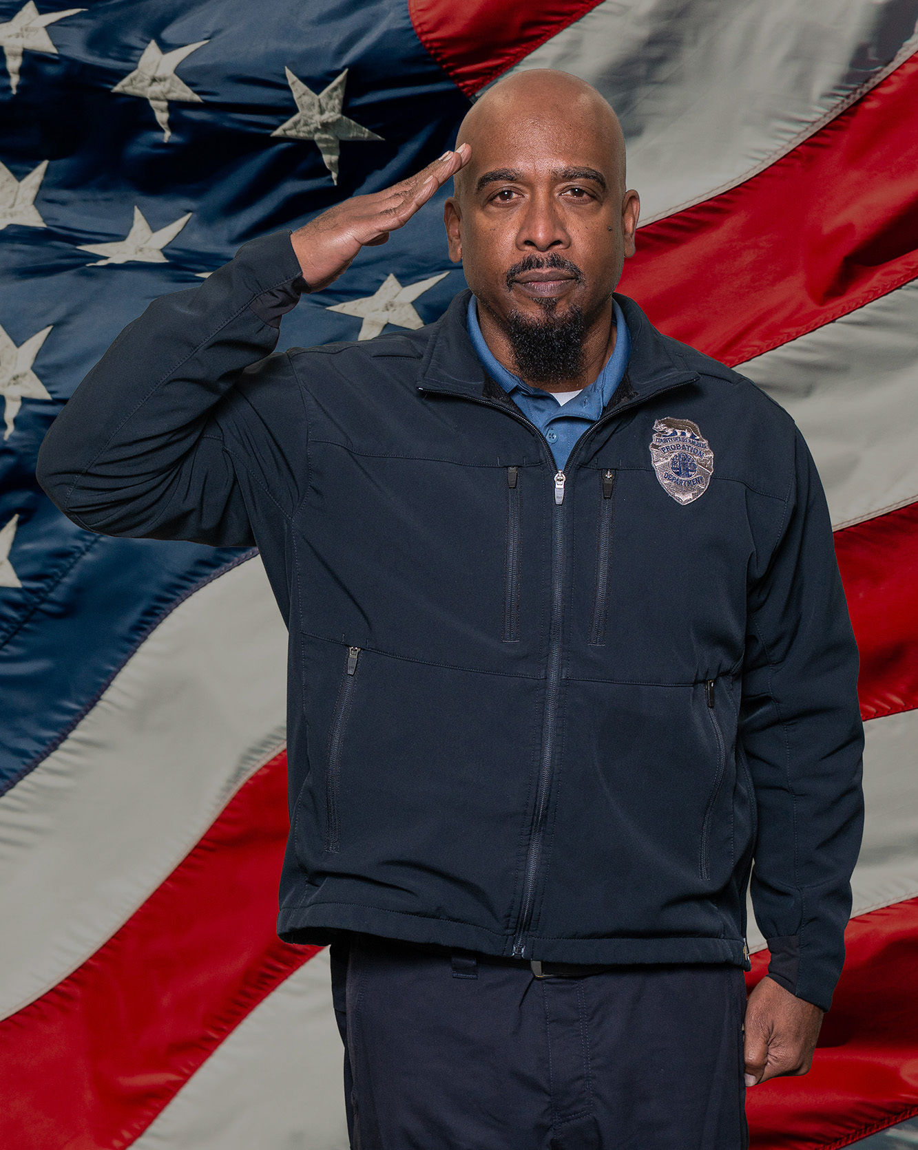 Deputy Probation Officer I standing at attention in front of US Flag