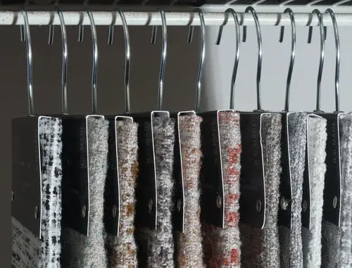 Fabric and textile hanging samples on hooks in a showroom rack