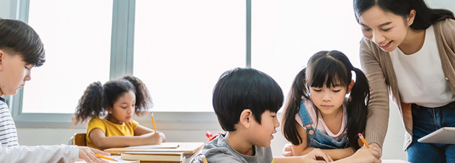 A teacher helping her young students with an assignment..