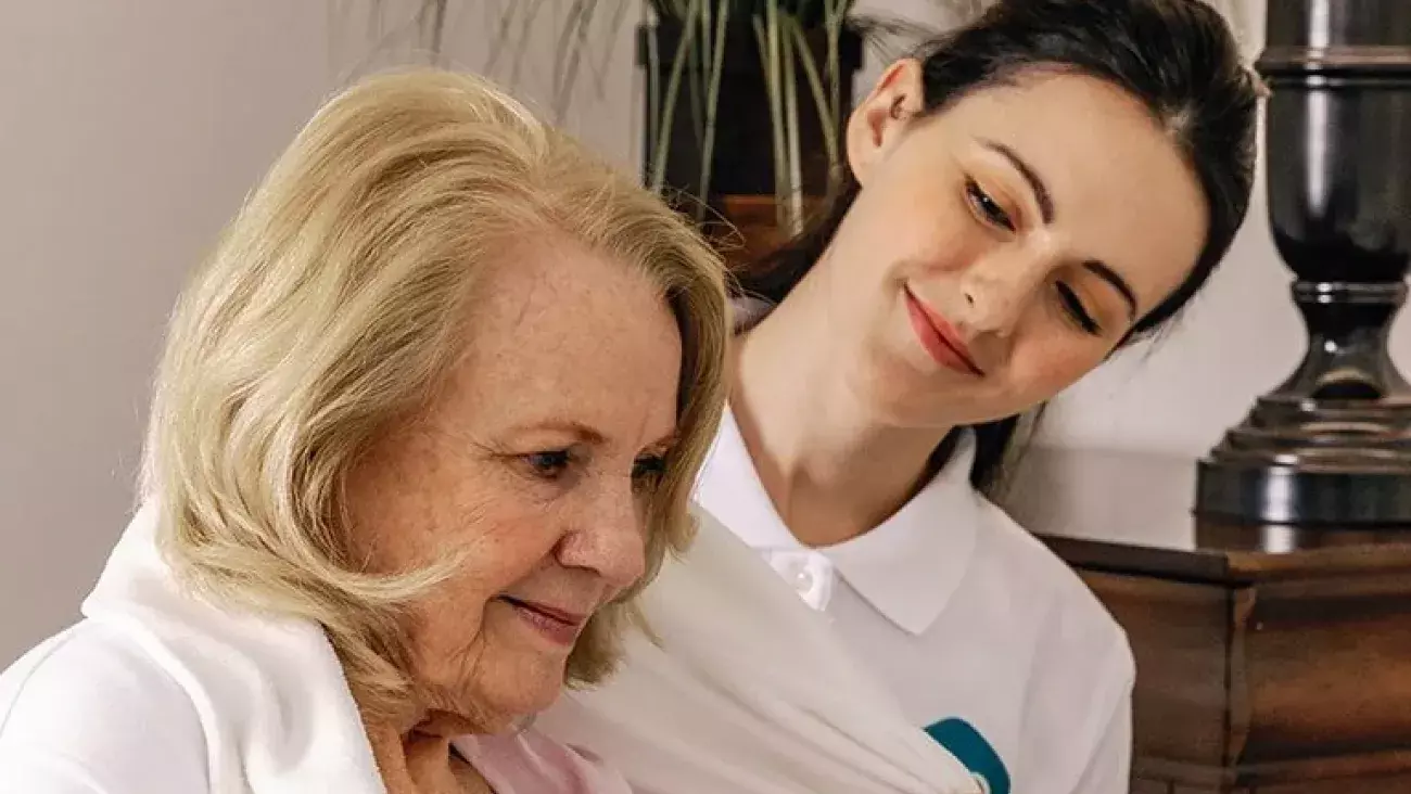 Caregiver assisting elderly woman
