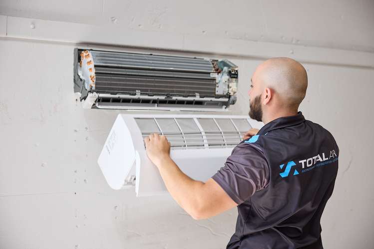 Technician installing a split system air conditioner