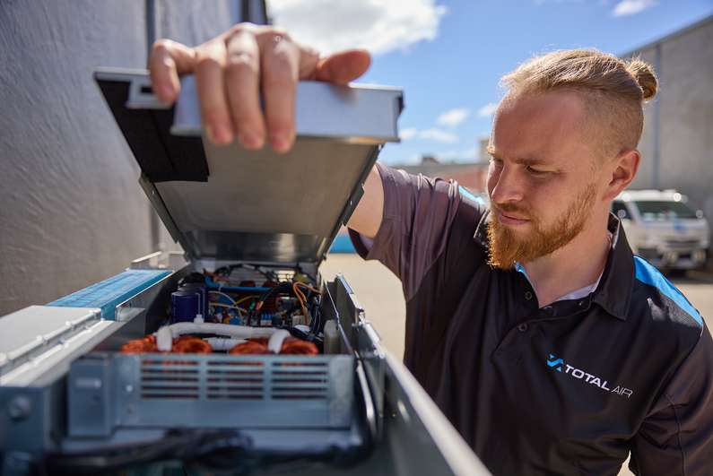 Technician servicing an air conditioning system