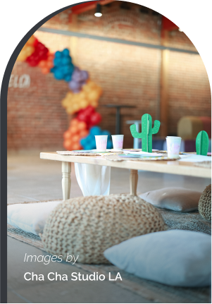 Area featuring a small table with cups and decorations, large brick wall in background.