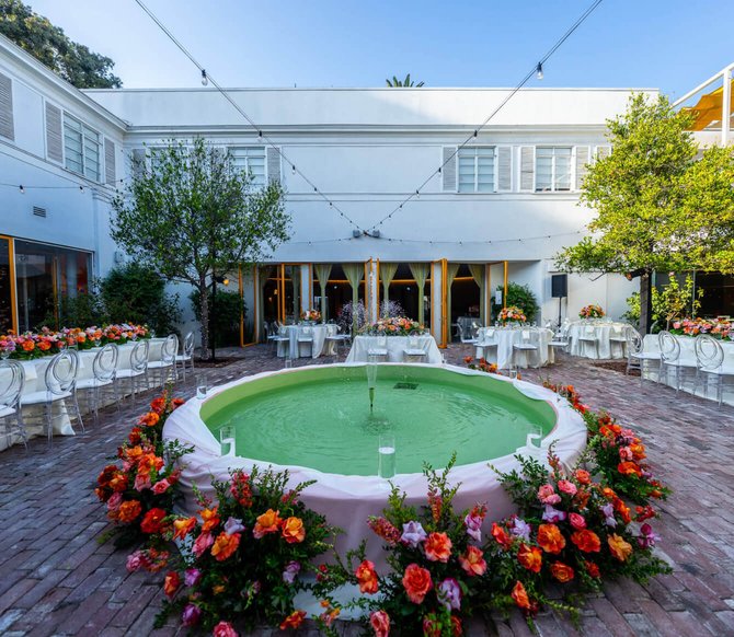 Outdoor wedding reception at a brick courtyard with a central fountain.