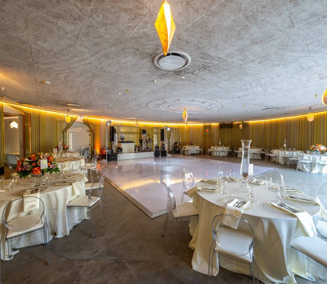 Modern, circular wedding reception hall with a central white dance floor.
