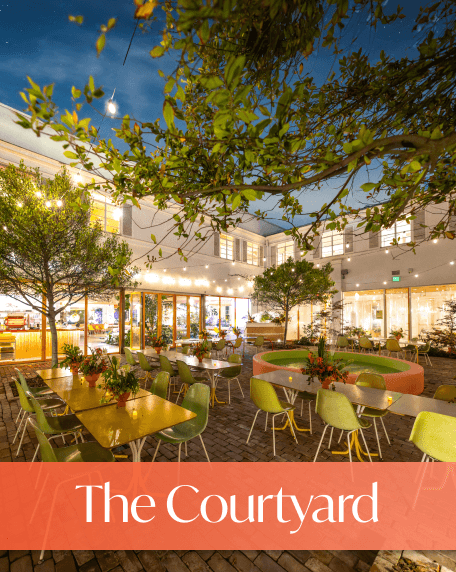 Courtyard at Night - Desks and tables lit by lights at nighttime.