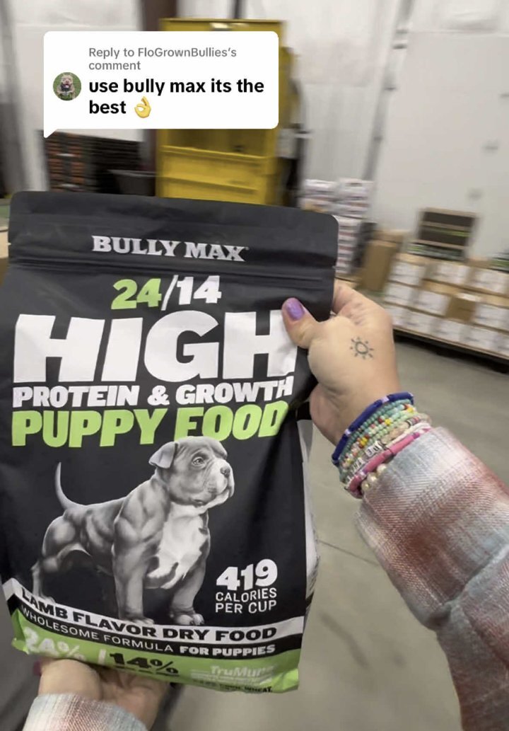 Bag of Bully Max 24/14 High Protein and Growth Puppy Food held up in the Bully Max warehouse, replying to a customer comment: use Bully Max, it's the best