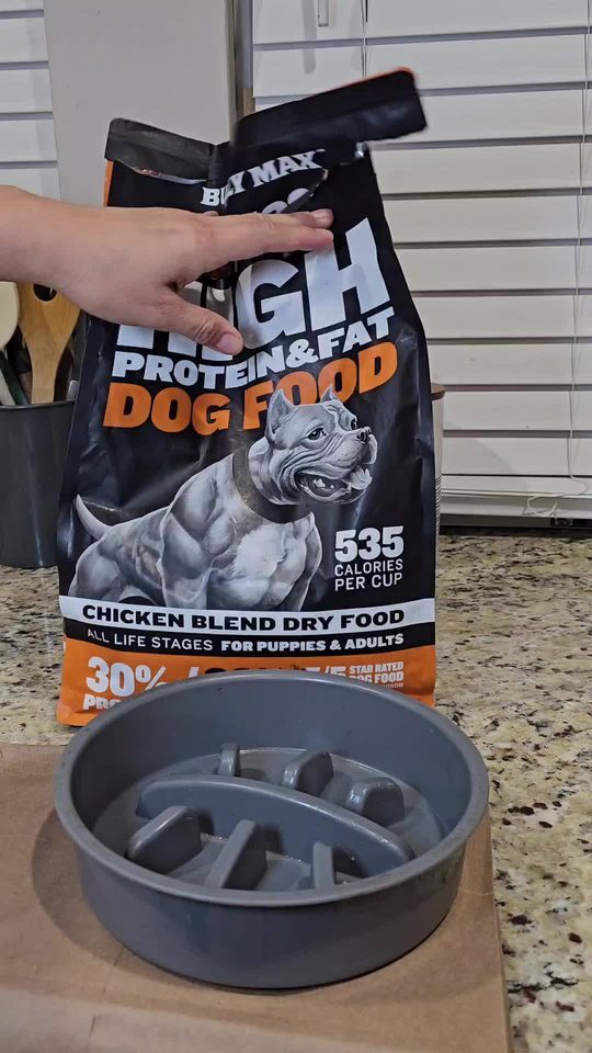 Bag of Bully Max 30/20 High Protein and Fat dog food, 535 calories per cup, next to a slow-feeder bowl