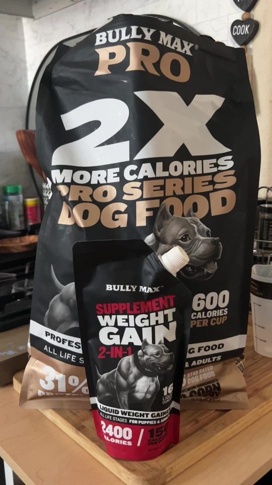 Bag of Bully Max PRO Series 2X More Calories dog food and a Weight Gain 2-in-1 pouch on a kitchen counter
