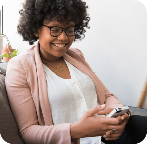 woman smiling ordering birth control online through mobile phone