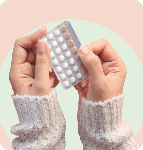 woman's hands holding birth control