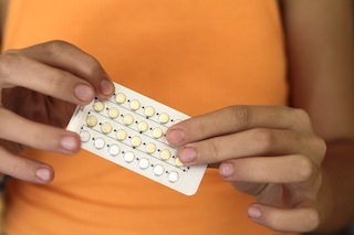 woman holding birth control medication