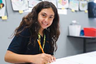Girl Smiling at Desk