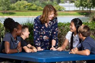 Image of teacher smiling with middle school  students.
