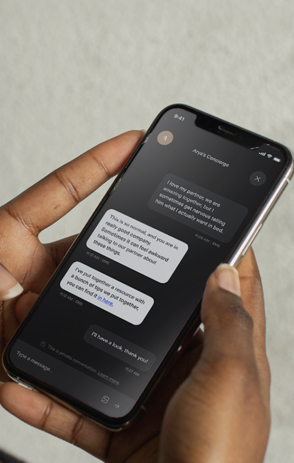 Hands holding a phone with the Arya Concierge chat