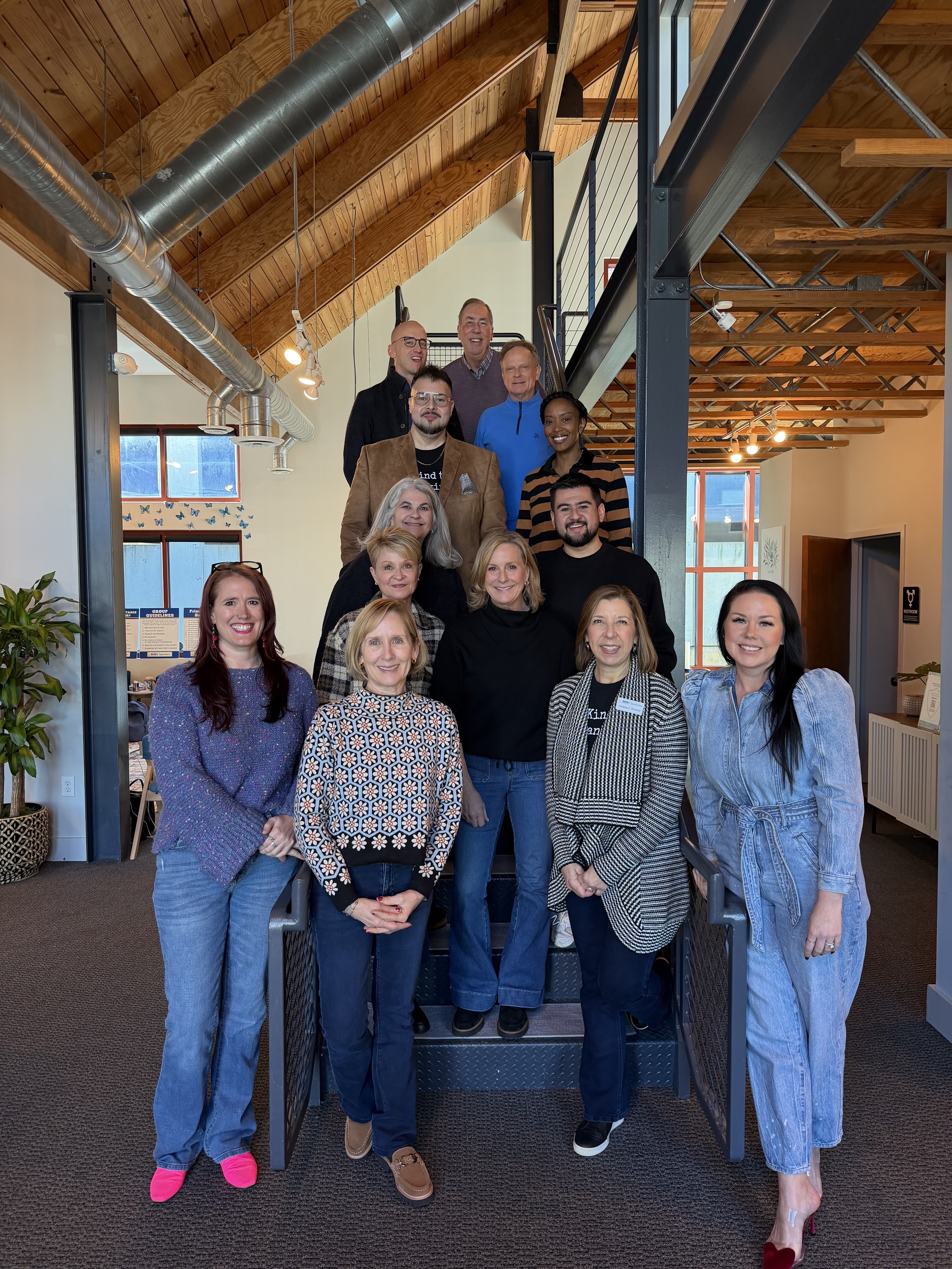 NAMI Charlotte team members and community partners gathered together on an indoor staircase.
