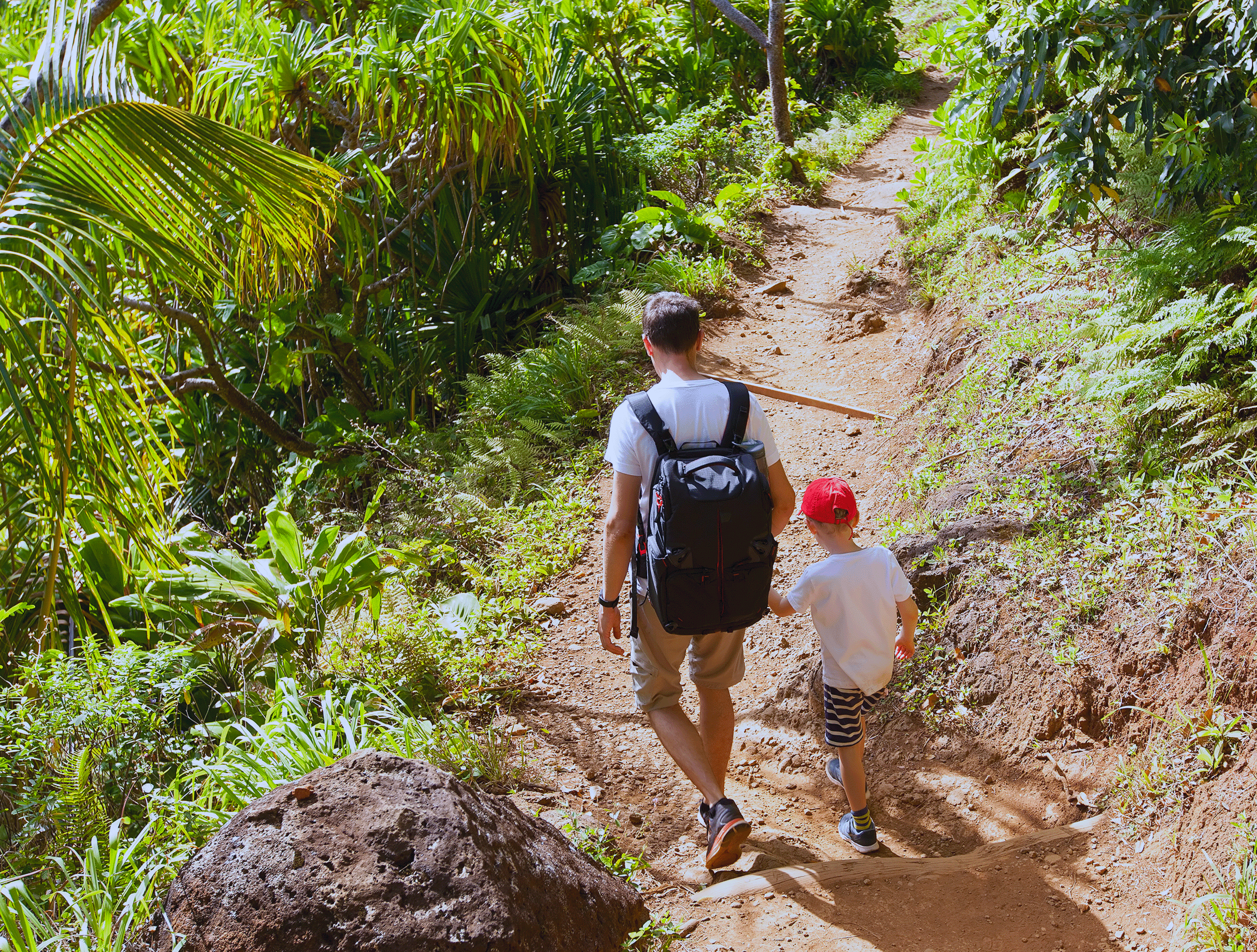 father with child walking down a hiking trail