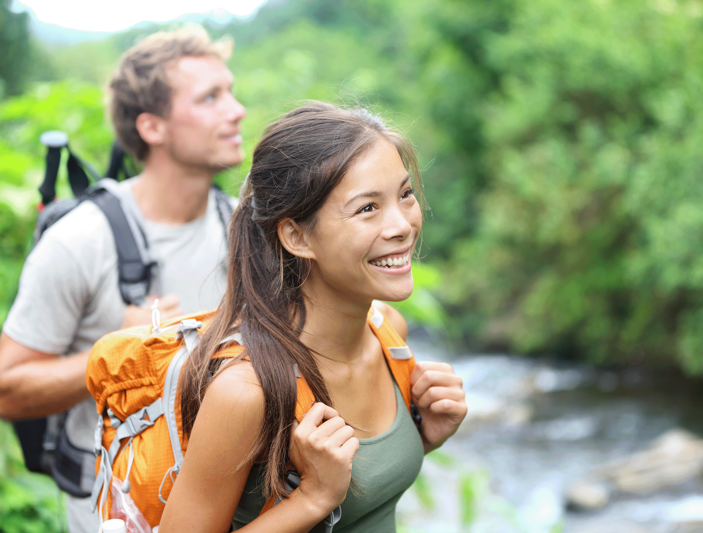 Young couple (man and woman) standing along a stream
