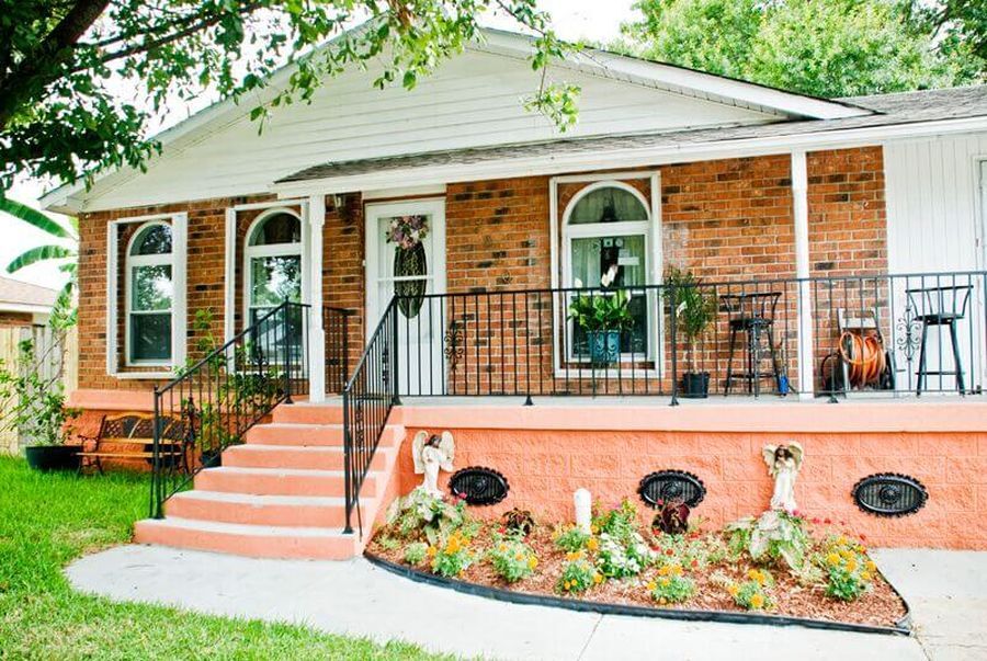 Elevated brick home with finished landscaping