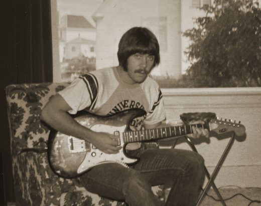 Ross at 18, playing an electric guitar