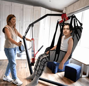 Mamá moviendo a su hijo con la grúa en casa